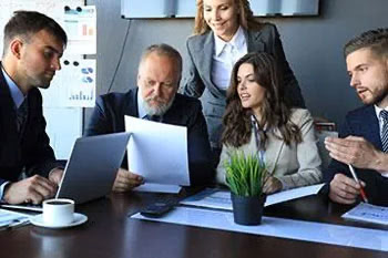 Team aus Geschäftsleuten beraten und schauen auf Laptop